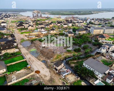Aus der Vogelperspektive verstreute Häuser und Gebäude mit einem großen Müllhaufen in der Mitte, Ede Okia Community Road, Port Harcourt, R Stockfoto