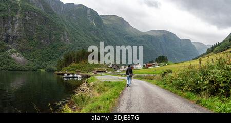 Eine Frau mit ihrem Hund wandert durch Naeroyfjord, Norwegen Stockfoto