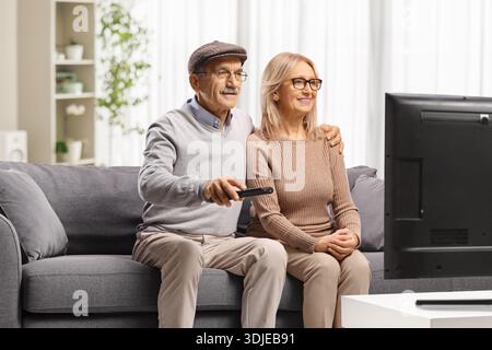 Ein älteres Paar sieht sich eine Sendung im Fernsehen im Wohnzimmer an Stockfoto