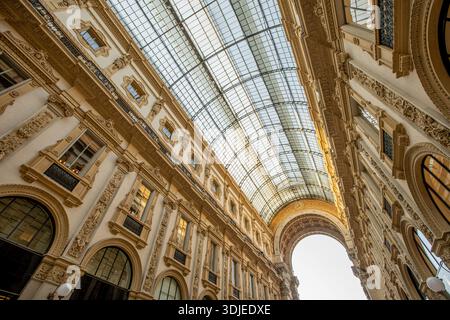 Besucher bewundern die exquisite Glasdecke und die kunstvollen Details der Galleria Vittorio Emanuele II in Mailand an einem sonnigen Nachmittag. Stockfoto