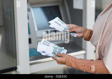 Frau nimmt Geld vom Geldautomaten der Bank, Nahaufnahme. Geldautomaten Stockfoto