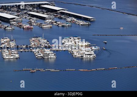 Überdachte Docks und Bootsreihen füllen einen geschäftigen Yachthafen am Lake Mead in der Lake Mead National Recreation Area, USA, mit Wellenbrechern und Wachen im Wasser. Stockfoto