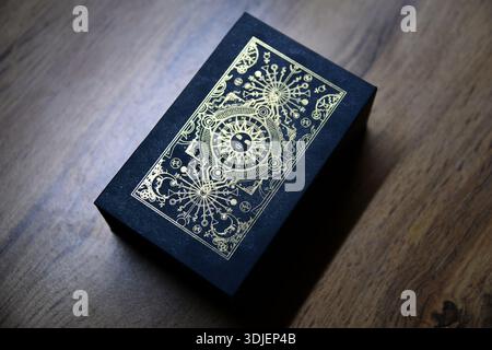 Wahrsager- und Whitcraft-Konzept mit Tarotkarten auf rotem Samt, umgeben von einer magischen Kristallkugel, einem goldenen Armband, einem Buch und einer Holzbox Stockfoto