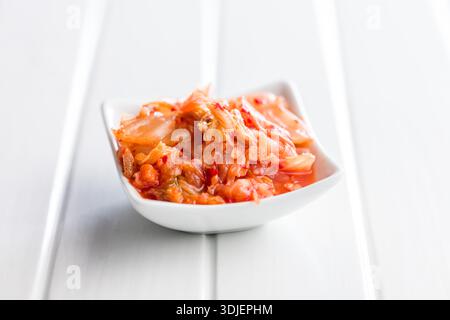 Fermentierter Kohl. Kimchi. Koreanisches Essen in einer Schüssel auf einem weißen Tisch. Stockfoto
