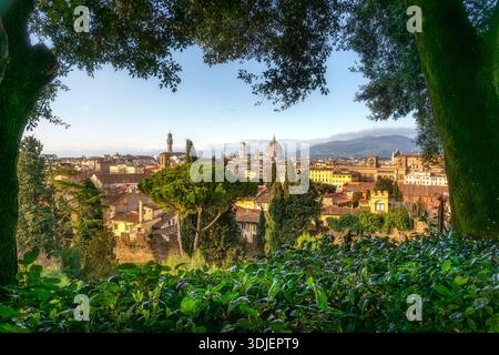 Malerischer Blick auf die Stadt Florenz durch grüne Bäume. Mit der Kathedrale Santa Maria del Fiore und dem Palazzo Vecchio unter einem klaren blauen Himmel, Stockfoto
