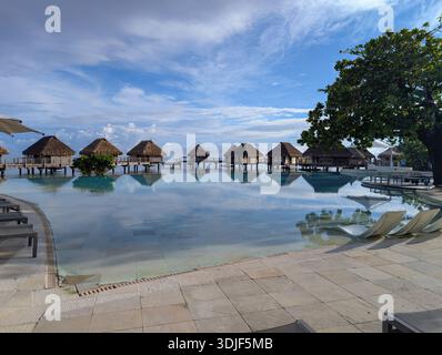 Moorea, Tahiti - 18. April 2025: Luxuriöse Bungalows über dem Wasser und ein Pool auf einer Französisch-Polynesischen Insel Stockfoto