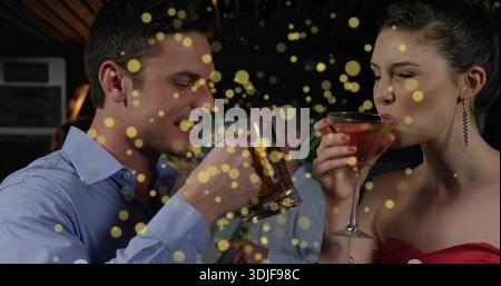 An der Bar schlürft man Mann mit blauem Hemd und Frau mit roter Verkleidung, hält Bierbecher und Martini in der Hand Stockfoto