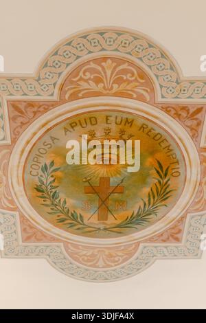 An der Decke befindet sich ein zentrales Emblem mit einem Auge mit Krone und einem Kreuz, das von dekorativen Elementen umgeben ist. Stockfoto