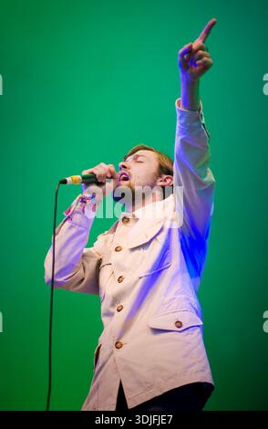 Tom Meighan tritt live mit Kasabian beim Glastonbury Festival am 25. Juni 2005 in Somerset auf. Das Album wurde auf der Pyramid Stage fotografiert und erschien während des Tourzyklus für das Debütalbum Kasabian aus dem Jahr 2004. Mit Singles wie „Club Foot“, „L.S.F.“ und „Proceed Beats“, die ihren Durchbruch trieben, lieferte die Indie-Rock-Band von Leicester eine energiereiche Festivalperformance. Dieses Bild fängt Meighan Mid-Song ein und spiegelt die Dynamik des rasanten Aufstiegs Kasabian in der britischen Alternative Rock Szene wider. Stockfoto