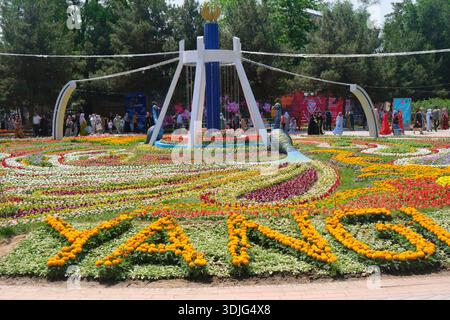 Aufwändiges Blumenbeet mit Pfauenstatuen. Beim jährlichen Frühlingsblumenfest im Babur Park. In Namangan, Fergana Valley, Usbekistan. Stockfoto