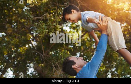 Happy, Dad und Kind mit Flugzeug im Hinterhof für Fantasy-Spiel, Verbundenheit und Unterstützung. Niedriger Winkel, Mann und Sohn mit fliegendem Spiel im Freien zu Hause Stockfoto