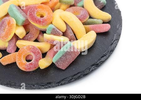 Jelly Bonbons auf Steinplatte, isoliert auf weißem Hintergrund. Stockfoto