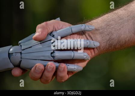 Roboter und menschliche Hände vertrauen auf Handshake. Roboterhände mit menschlicher Pflege. Roboter macht sich mit menschlicher Verbindung vertraut. Menschliche Hände mit Roboterunterstützung. Stockfoto