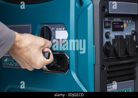 Ein Mann zieht den Griff eines Generatoranlassers, manueller Start eines Generators, Stockfoto