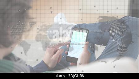 Klopfende Erwachsene Frau, die ein Smartphone im Wohnzimmer hält, blaue Jeans, blauer Pullover, Kartenüberzug trägt Stockfoto