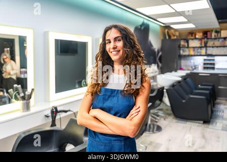 Selbstbewusste Friseurin lächelt im Friseursalon Stockfoto