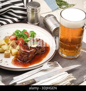 Eine köstliche Mahlzeit mit perfekt gekochten Rindersteaks, präsentiert auf einem weißen Teller. Begleitet von gewürzten gerösteten Kartoffelstückchen, frischen Brokkoli-Röschen, an Stockfoto