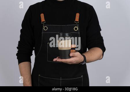 Nahaufnahme der Hände, die Kaffee und einen Stapel Kartons halten Stockfoto