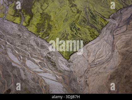 Luftaufnahme des starken Kontrasts zwischen dem leuchtend grünen moosbedeckten Hochland und den komplizierten Mustern der Gletscherflüsse darunter, Selfoss, Sve Stockfoto