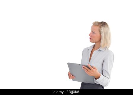 Frau, die in einer hellen Bluse steht, graues Klemmbrett hält und direkt in weißes Studio schaut, Kopierraum. Professionell, Tablet, Hintergrund, Solo, minimalistisch, Stockfoto
