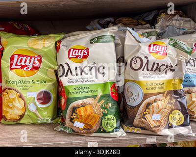 Lay's Kartoffelchips. Griechische Snacks (Ολικής) Aromen wie Salz und Essig sowie Sauerrahm und schwarzer Pfeffer in den Regalen des Ladens. Stockfoto