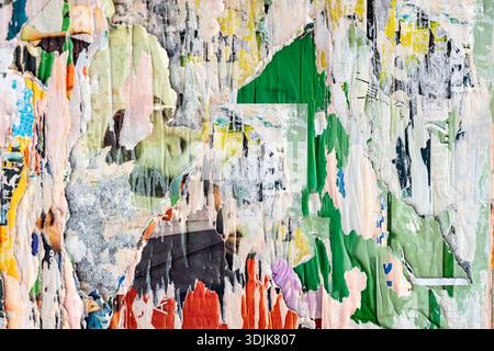 Abstrakte Nahaufnahme einer zerrissenen urbanen Plakatwand-Collage aus mehrschichtigem Papier, hellen, rauen Grunge-Texturen. Verdichtete Papieroberfläche, abblätternde Farbe, Grafik Stockfoto