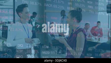 Zwei Frauen in Businesskleidung und Lanyards mit Tassen im Pausenraum, Ticker-Overlay Stockfoto