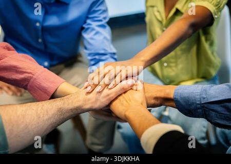 Verschiedene Geschäftsteams, die Hände stapeln, um Einheit zu zeigen Stockfoto