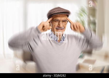 Senior-Mann mit den Fingern an den Schläfen, der an Kopfschmerzen und Schwindel leidet Stockfoto