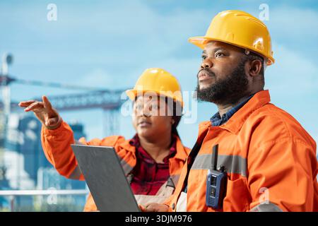 Nahaufnahme eines Offshore-Plattformentwicklungsteams, das Derrick-Managementsysteme für eine effizientere Ölförderung konfiguriert. Bohrgerätkollegen, die Meeresbodenanalysen mit Laptop-Software durchführen Stockfoto