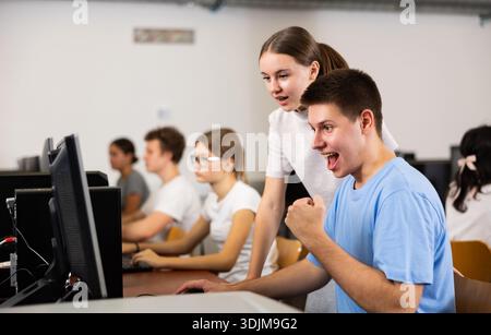 Teenager-Mädchen hilft Freundin, Probleme am Computer in der Schule zu lösen Stockfoto