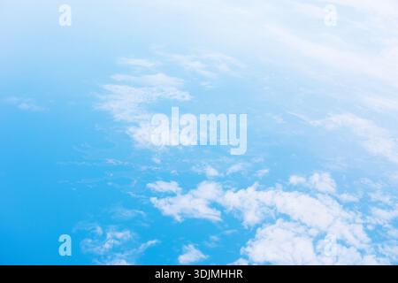 Der ruhige Blick aus der Luft zeigt verstreute weiße Wolken, die über dem riesigen blauen Ozean schweben. Die Szene fängt die heitere Atmosphäre der Erde und den friedlichen Rhythmus ein Stockfoto