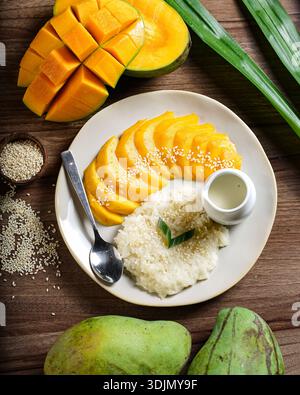 Eine Nahaufnahme eines beliebten thailändischen Desserts, Mango-Kleberreis, kunstvoll auf einem Teller angeordnet. Es enthält süßen Kleberreis mit Sesamsamen, al Stockfoto