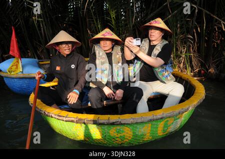 Touristen genießen die einzigartige und traditionelle Coracle Tour im Bay Mau Kokosnusswald, Vietnam Stockfoto