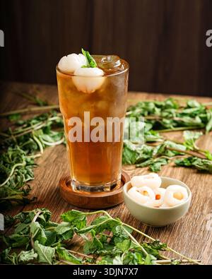 Köstlicher Eistee serviert mit Tapioka-Perlen und frischen Kräutern auf einem Holztisch, perfekt für einen Sommerdrink. Stockfoto
