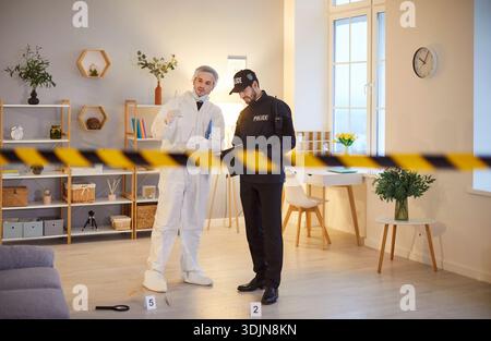 Polizeidetektiv und forensischer Wissenschaftler arbeiten am Tatort in Haus oder Wohnung Stockfoto