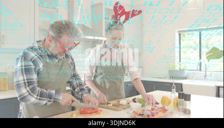 Kochpaare mit Schürzen und Rentiergeweihen, die Paprika und Zwiebeln auf der Kücheninsel hacken Stockfoto