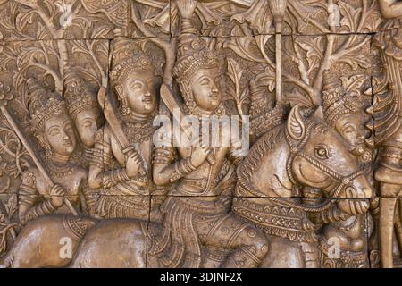 Komplizierte Reliefschnitzerei eines alten Kriegers auf einem Pferd. Diese historische Steinskulptur aus südostasiatischer Tempelwand zeigt Soldaten mit Fokus Stockfoto