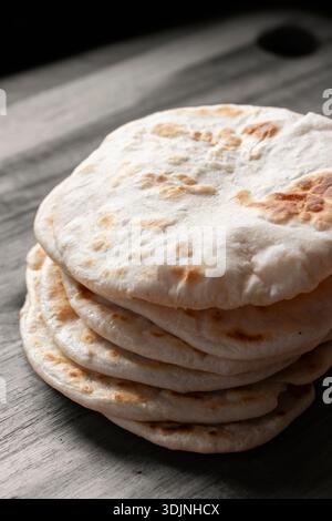 Hausgemachtes Fladenbrot auf einem hölzernen Schneidebrett. Einfaches Rezeptkonzept für hausgemachtes Brot. Stockfoto
