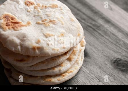 Hausgemachtes Fladenbrot auf einem hölzernen Schneidebrett. Einfaches Rezeptkonzept für hausgemachtes Brot. Stockfoto