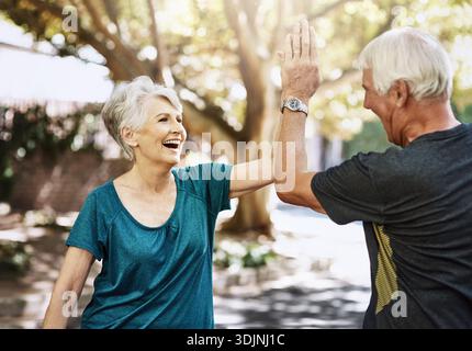 Seniorenpaar, Fitness und High Five im Park mit Unterstützung, Aufregung und Leistung im Sommer. Alte Leute, feiern und glücklich mit Zielen, Erfolg Stockfoto