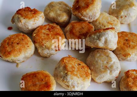 Frittierte goldene Fleischbällchen auf einem weißen Teller. Hausgemachte Vorspeise mit Schweinefleisch oder Hähnchenfleisch. Stockfoto