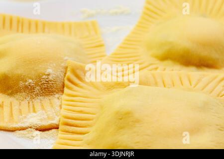 Frisch zubereitete rohe Ravioli-Pasta-Quadrate mit Füllung zum Kochen. Hausgemachte italienische Speisen. Stockfoto