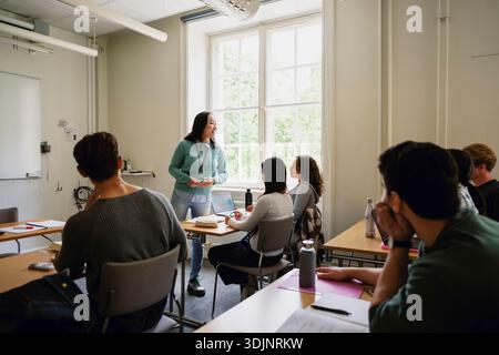 Eine Professorin unterrichtet junge Studenten im Klassenzimmer am College Stockfoto
