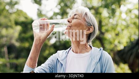 Wasser, Trinken und ältere Frau in der Natur zum Entspannen mit Fitness, Training oder Bewegung im Park. Flasche, Wellness und ältere Frau in Stockfoto