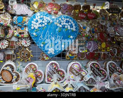Traditionelle tschechische Lebkuchenkekse in verschiedenen Formen und Farben, die auf einer Messe ausgestellt werden, mit einem großen blauen Herz mit der Aufschrift „Z lásky“. Stockfoto