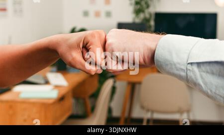 Erster Stoß zwischen Kollegen im Büro als Symbol für Teamarbeit und Zusammenarbeit Stockfoto