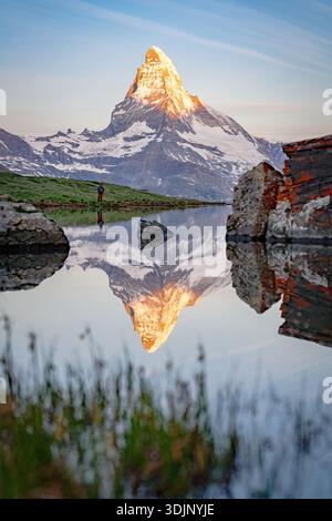 Blick auf den majestätischen Matterhorn, der sich bei Sonnenaufgang im ruhigen Stellisee spiegelt, dessen Gipfel vom goldenen Licht der Morgendämmerung geküsst wird, Zermatt, V Stockfoto