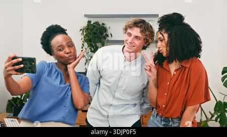 Drei Freunde Nehmen Selfie Zusammen Im Modernen Bürobereich Für Lässiges Teamfoto Stockfoto