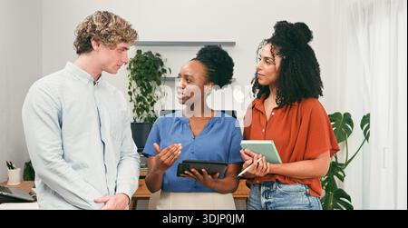 Drei Kollegen Diskutieren Projekt In Modern Office Während Des Teammeetings Stockfoto